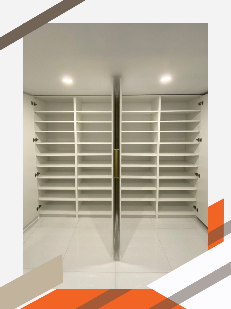 Two floor-to-ceiling cabinets in a clean, modern finished basement of a residential home. The doors of the cabinets are open to reveal 2 columns and 10 rows of shelving per cabinet.